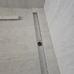 תעלת ניקוז לינארית משוקעת ברצפת אריחים נקייה