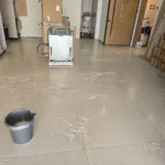 שטיפת רצפת אריחים לאחר בנייה, מים ודלי על הרצפה
