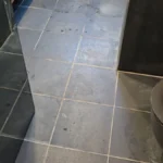 מסדרון עם אריחים בגוון אבן כהה, נקי לאחר בנייה