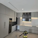 מטבח עם שואב אבק על הרצפה במהלך ניקיון לאחר בנייה