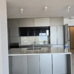 מטבח מוגמר עם ארונות לבנים בגוון עץ, נקי למסירה