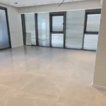 חדר ריק ומואר עם חלונות מהרצפה עד התקרה, נקי למסירה