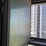 חלון נקי מהרצפה עד התקרה עם נוף עירוני